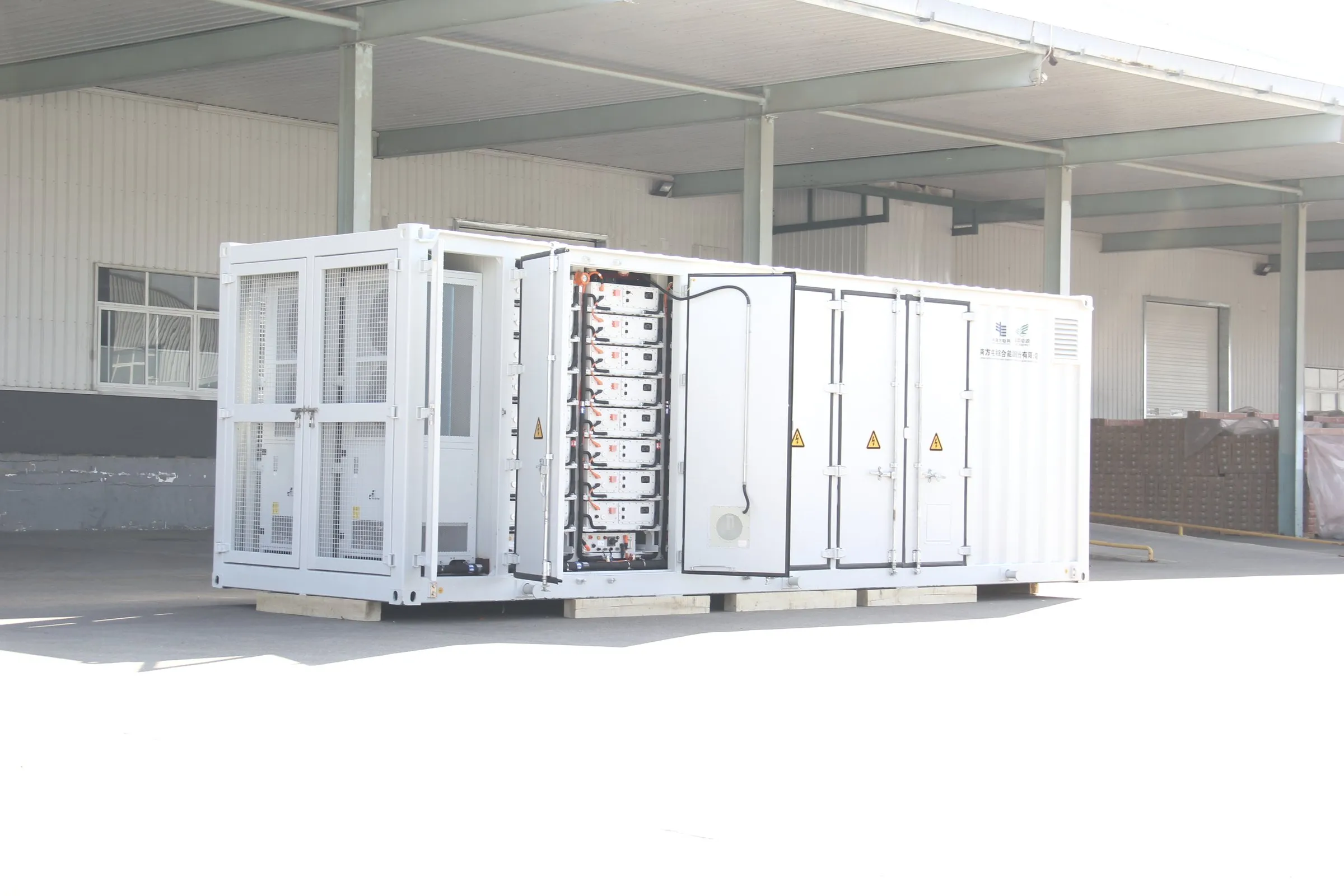 Contentor de baterias de 5 MWh aberto durante a integração, com os racks à vista