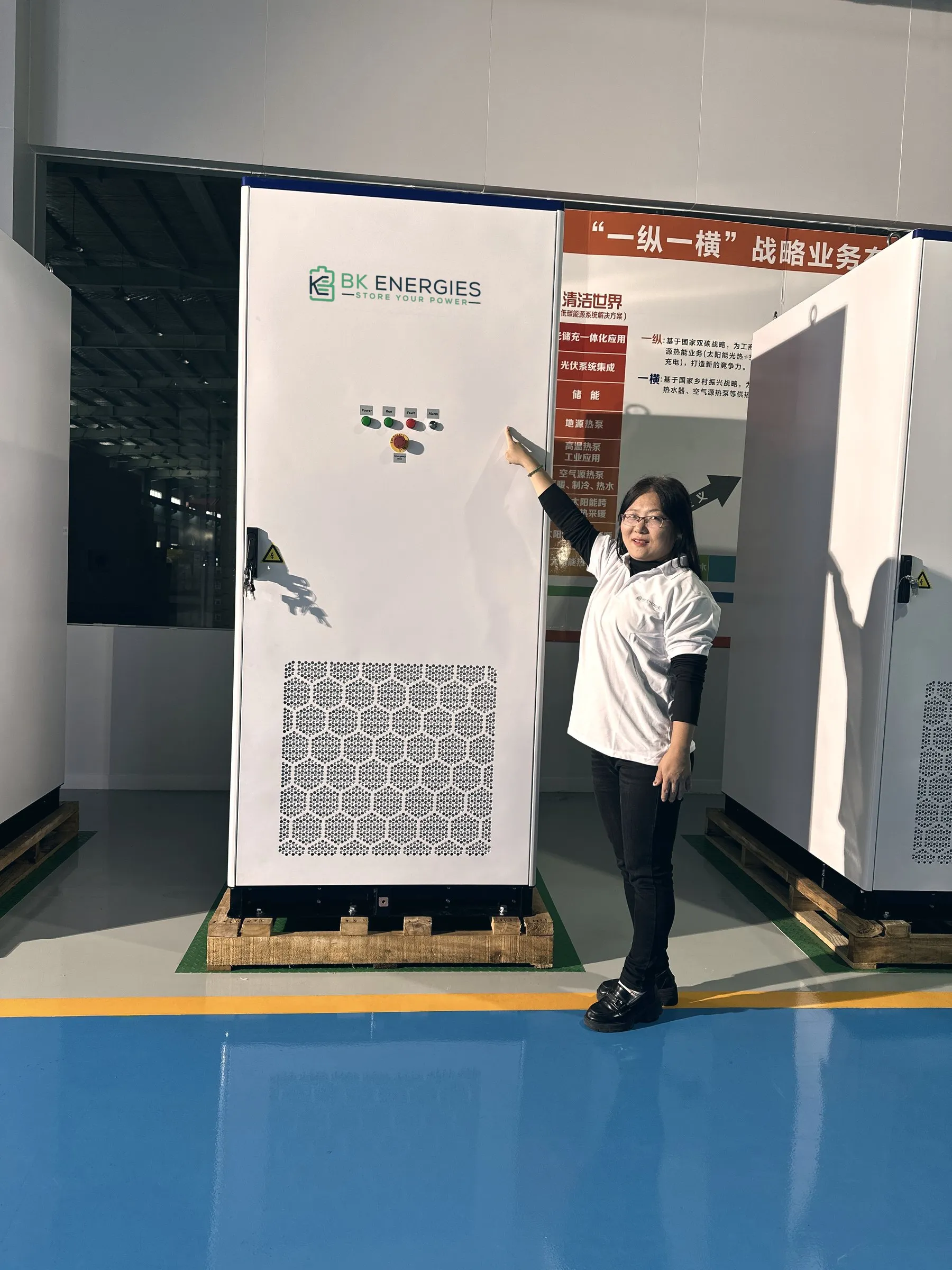 Técnica de BK Energies junto a un equipo all-in-one con el logotipo BK, en la nave de integración