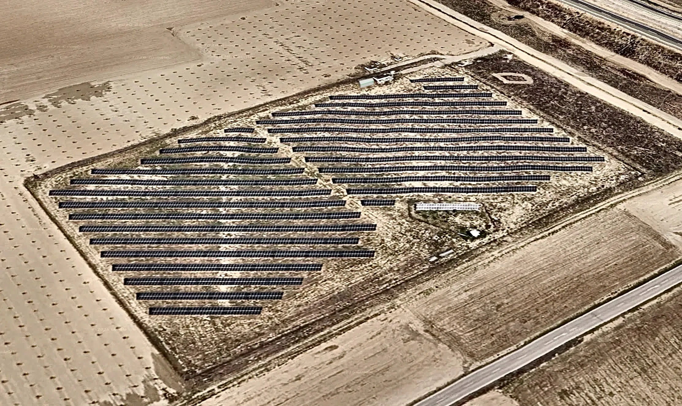 Widok z lotu ptaka na farmę fotowoltaiczną w Ocaña z kontenerem bateryjnym obok budynków wejściowych